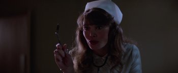 Movie still from “Halloween II” (1981), directed by Rick Rosenthal – A woman in a nurse's outfit holding a spoon; Close Up shot, Low angle