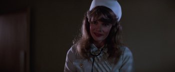 Movie still from “Halloween II” (1981), directed by Rick Rosenthal – A woman wearing a nurse's uniform with a stethoscope around her neck; Close Up shot, Low angle