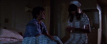Movie still from “Halloween II” (1981), directed by Rick Rosenthal – A man and a woman sitting on a bed in a room; Medium shot, Low angle