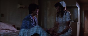 Movie still from “Halloween II” (1981), directed by Rick Rosenthal – A man and a woman sitting on a bed; Medium shot, Low angle