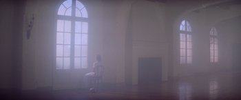 Movie still from “Halloween II” (1981), directed by Rick Rosenthal – A person sitting in a chair in a room with a fire place; Extreme Wide shot, Low angle