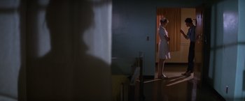 Movie still from “Halloween II” (1981), directed by Rick Rosenthal – A woman standing in front of a door in a room; Wide shot, Low angle