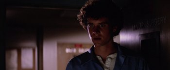 Movie still from “Halloween II” (1981), directed by Rick Rosenthal – A young man with curly brown hair wearing a blue jacket; Close Up shot, Low angle
