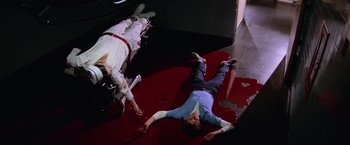 Movie still from “Halloween II” (1981), directed by Rick Rosenthal – Two people are lying on the floor of a room; Wide shot, High angle