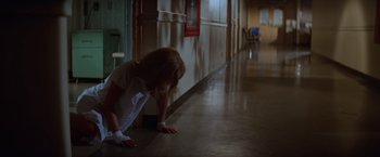 Movie still from “Halloween II” (1981), directed by Rick Rosenthal – A little girl in a white dress leaning against a wall; Wide shot, Low angle