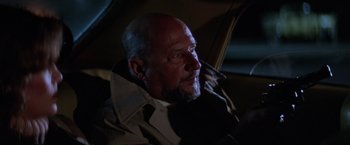 Movie still from “Halloween II” (1981), directed by Rick Rosenthal – An older bald man with a beard and a jacket on; Close Up shot, Low angle