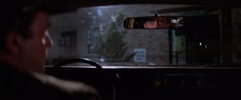 Movie still from “Halloween II” (1981), directed by Rick Rosenthal – A man looking out of the window of a car in the rain; Medium shot, Over the shoulder angle