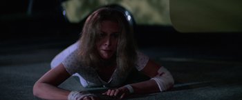 Movie still from “Halloween II” (1981), directed by Rick Rosenthal – A woman laying on the ground with a bandaged arm; Close Up shot, High angle