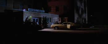 Movie still from “Halloween II” (1981), directed by Rick Rosenthal – A car parked in front of a building at night; Extreme Wide shot, High angle