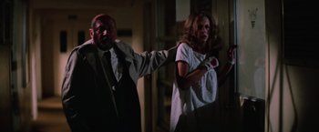 Movie still from “Halloween II” (1981), directed by Rick Rosenthal – A man and a woman in a dark room; Medium shot, Low angle