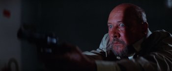 Movie still from “Halloween II” (1981), directed by Rick Rosenthal – An older man with a goatee and a beard is holding a cell phone; Close Up shot, Low angle