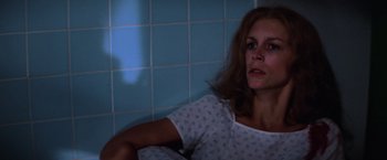 Movie still from “Halloween II” (1981), directed by Rick Rosenthal – A woman sitting in a bathroom next to a tiled wall; Close Up shot, High angle