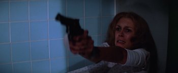 Movie still from “Halloween II” (1981), directed by Rick Rosenthal – A woman holding a gun in a bathroom; Close Up shot, High angle