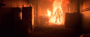Movie still from “Halloween II” (1981), directed by Rick Rosenthal – A person is standing in front of a fire; Wide shot, Low angle