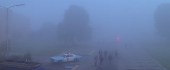Movie still from “Halloween II” (1981), directed by Rick Rosenthal – A group of people walking down a street in the fog; Extreme Wide shot, High angle