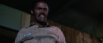 Movie still from “Halloween III: Season of the Witch” (1982), directed by Tommy Lee Wallace – A man with a beard and mustache is wearing a shirt and a tie; Close Up shot, Low angle