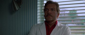 Movie still from “Halloween III: Season of the Witch” (1982), directed by Tommy Lee Wallace – A person wearing a suit and tie; Close Up shot, Low angle