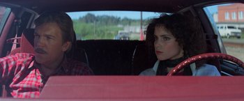Movie still from “Halloween III: Season of the Witch” (1982), directed by Tommy Lee Wallace – Two people sitting in the back seat of a car; Close Up shot, Over the shoulder angle