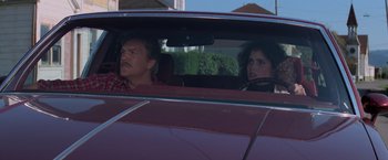 Movie still from “Halloween III: Season of the Witch” (1982), directed by Tommy Lee Wallace – A man and a woman sitting in the back seat of a car; Medium shot, Low angle