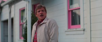 Movie still from “Halloween III: Season of the Witch” (1982), directed by Tommy Lee Wallace – A man standing in front of a pink house; Close Up shot, Low angle