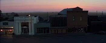 Movie still from “Halloween III: Season of the Witch” (1982), directed by Tommy Lee Wallace – A view of a city at dusk or dawn from a parking lot; Extreme Wide shot, High angle