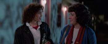 Movie still from “Halloween III: Season of the Witch” (1982), directed by Tommy Lee Wallace – Two women standing next to each other and one is holding a bottle; Close Up shot, Over the shoulder angle