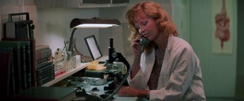 Movie still from “Halloween III: Season of the Witch” (1982), directed by Tommy Lee Wallace – A woman in a white lab coat talking on a phone; Medium shot, Low angle
