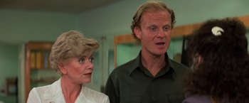 Movie still from “Halloween III: Season of the Witch” (1982), directed by Tommy Lee Wallace – A man and a woman standing next to each other in a room; Close Up shot, Over the shoulder angle