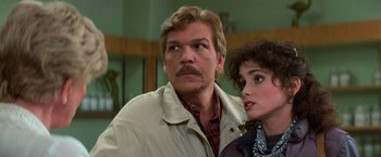 Movie still from “Halloween III: Season of the Witch” (1982), directed by Tommy Lee Wallace – A man and a woman standing next to each other in a room; Close Up shot, Over the shoulder angle