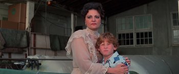 Movie still from “Halloween III: Season of the Witch” (1982), directed by Tommy Lee Wallace – A woman and a boy are posing for a picture; Close Up shot, Low angle