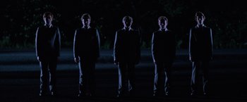 Movie still from “Halloween III: Season of the Witch” (1982), directed by Tommy Lee Wallace – A group of men standing next to each other in the dark; Wide shot, Low angle