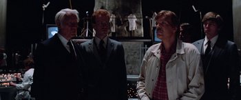 Movie still from “Halloween III: Season of the Witch” (1982), directed by Tommy Lee Wallace – A group of men standing next to each other in a room; Medium shot, Low angle