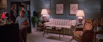 Movie still from “Halloween III: Season of the Witch” (1982), directed by Tommy Lee Wallace – A living room filled with furniture next to a lamp; Wide shot, High angle