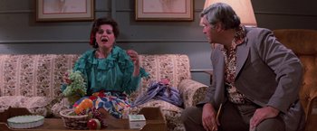 Movie still from “Halloween III: Season of the Witch” (1982), directed by Tommy Lee Wallace – Two people sitting in a living room talking to each other; Medium shot, Over the shoulder angle