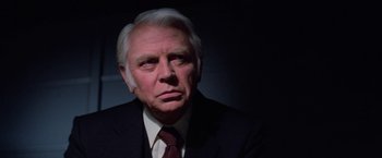 Movie still from “Halloween III: Season of the Witch” (1982), directed by Tommy Lee Wallace – An older man wearing a suit and tie; Close Up shot, Low angle