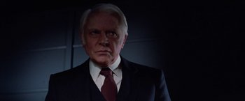Movie still from “Halloween III: Season of the Witch” (1982), directed by Tommy Lee Wallace – An older man wearing a suit and tie; Close Up shot, Low angle