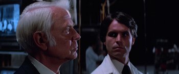 Movie still from “Halloween III: Season of the Witch” (1982), directed by Tommy Lee Wallace – A man and a woman in white lab coats looking at each other; Close Up shot, Over the shoulder angle