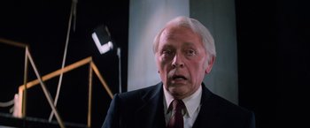 Movie still from “Halloween III: Season of the Witch” (1982), directed by Tommy Lee Wallace – An older man wearing a suit and tie; Close Up shot, Low angle