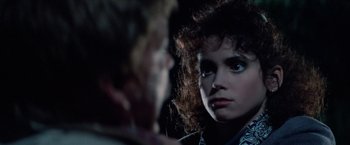 Movie still from “Halloween III: Season of the Witch” (1982), directed by Tommy Lee Wallace – A young woman stares into the distance while a younger man looks on; Close Up shot, Over the shoulder angle