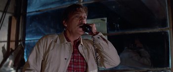 Movie still from “Halloween III: Season of the Witch” (1982), directed by Tommy Lee Wallace – A man talking on a phone while standing in a room; Close Up shot, Low angle