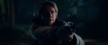 Movie still from “Halloween Kills” (2021), directed by David Gordon Green – A man is holding a gun in a dark room; Close Up shot, Low angle