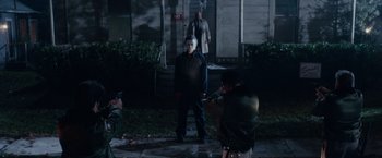 Movie still from “Halloween Kills” (2021), directed by David Gordon Green – A person taking a picture of a person in a suit; Wide shot, Low angle