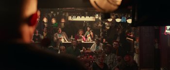 Movie still from “Halloween Kills” (2021), directed by David Gordon Green – A group of people sitting around a bar; Wide shot, Over the shoulder angle