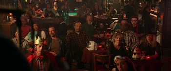 Movie still from “Halloween Kills” (2021), directed by David Gordon Green – A group of people sitting at a table in a room; Wide shot, High angle
