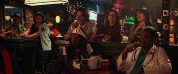 Movie still from “Halloween Kills” (2021), directed by David Gordon Green – A group of people sitting at a table with drinks; Medium shot, Over the shoulder angle