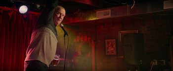 Movie still from “Halloween Kills” (2021), directed by David Gordon Green – A man standing at a microphone in front of a glass of beer; Medium shot, Low angle
