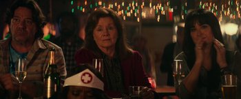 Movie still from “Halloween Kills” (2021), directed by David Gordon Green – An older woman sitting at a table with a glass of wine in front of her; Close Up shot, Over the shoulder angle