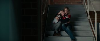 Movie still from “Halloween Kills” (2021), directed by David Gordon Green – Two young women sitting on the steps of a building; Medium shot, Overhead angle