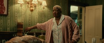 Movie still from “Halloween Kills” (2021), directed by David Gordon Green – An older woman standing in front of a chandelier; Medium shot, Low angle