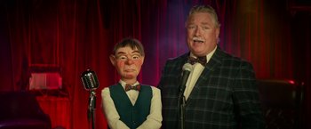 Movie still from “Halloween Kills” (2021), directed by David Gordon Green – A man standing next to another man with a microphone; Medium shot, Low angle